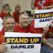 Photo of UAW Daimler members holding "Stand Up Daimler" UAW signs.