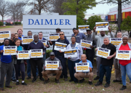 Photo of Daimler workers holding UAW signs that say: "United for a Strong Contract."