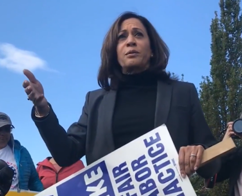 Photo of then-U.S. Senator Kamala Harris walking the picket line with UAW members on strike at General Motors.