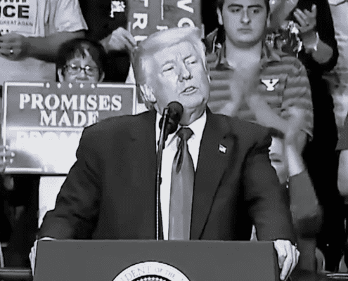 Black and white screenshot of Donald Trump giving a speech.