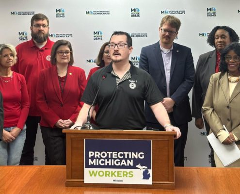 Photo of UAW Local 228 member JJ Jewell addressing the media during a Michigan House Democrats press conference introducing the May Day bill package to expand workers’ rights on May 1, 2025.