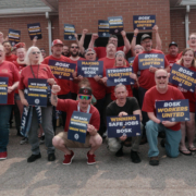 Photo of workers who work at BOSK in Glendale, KY, wearing red shirts and holding UAW signs.