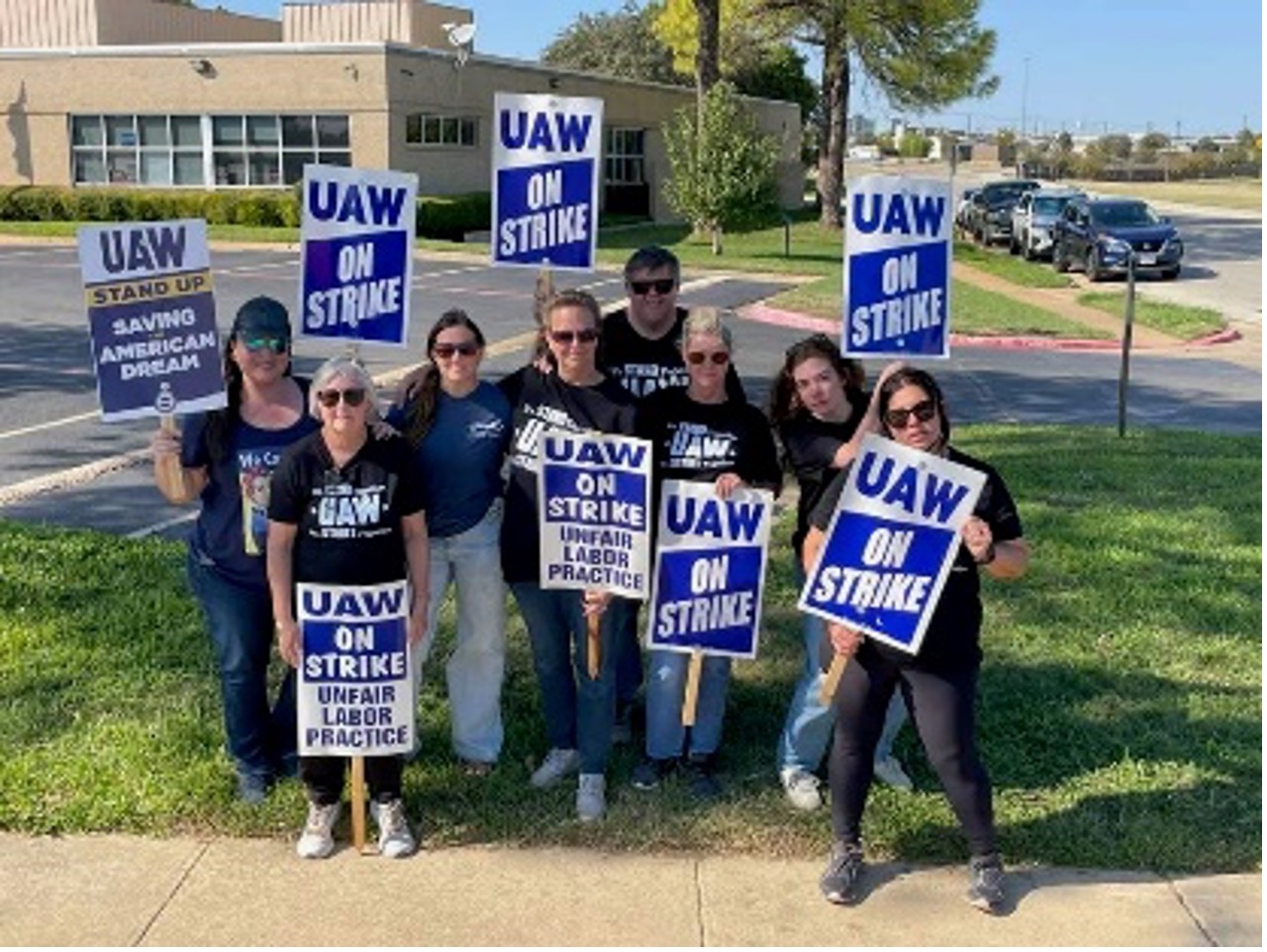 UAW Region 8, Local 128 – Association of Professional Flight Attendants on Strike posing for a photo on the lawn under a tree