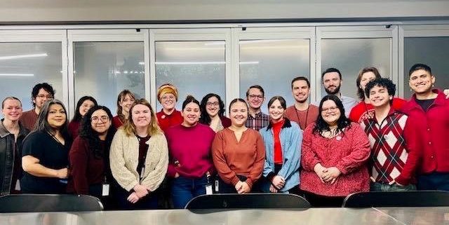 members stand inside office building for photo