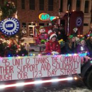 UAW Region 4 Local 95 Healthcare Sector 2 UAW wheel sign, thank you for support and solidarity banner, Christmas lights, photo of children and adults posing in front of neighborhood homes in winter attire.