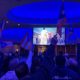 UAW members from Region 9A wave Puerto Rican flags as they watch Bad Bunny's Super Bowl LX halftime performance.