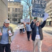 Members walking on walkway in front of office building, wearing fall weather attire