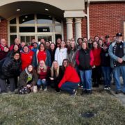 Group of people standing in front of building.