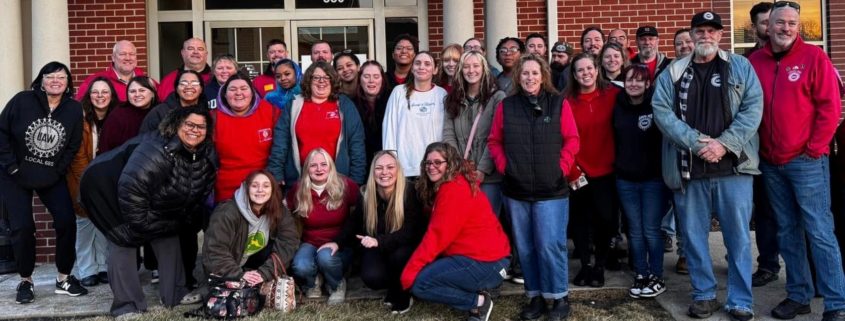 Group of people standing in front of building.