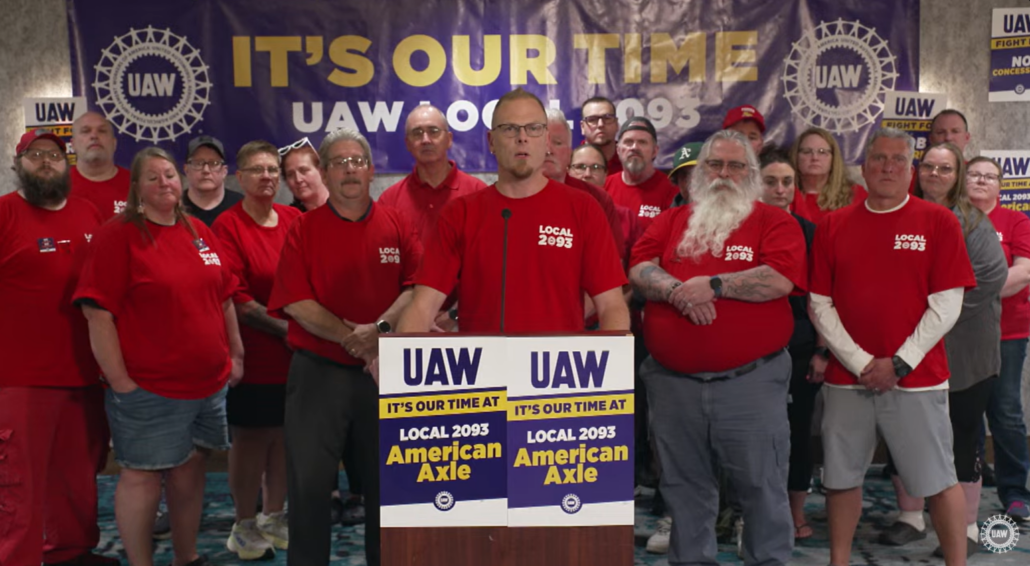 Screenshot of UAW Local 2093 bargaining chair Josh Jager, President Shawn Fain, Region 1D Director Steve Dawes, and the local bargaining committee during a UAW livestream announcing a tentative agreement at American Axle in Three Rivers, MI, on June 10, 2026.